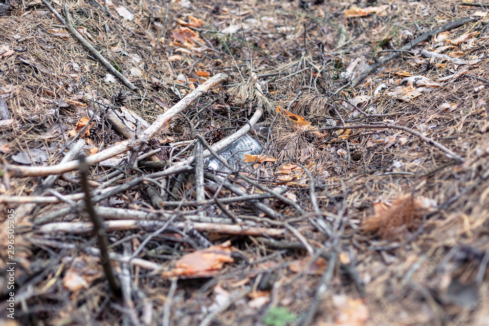 White plastic bottle on the ground in a pine forest. White plastic bottle on the ground in a pine forest.