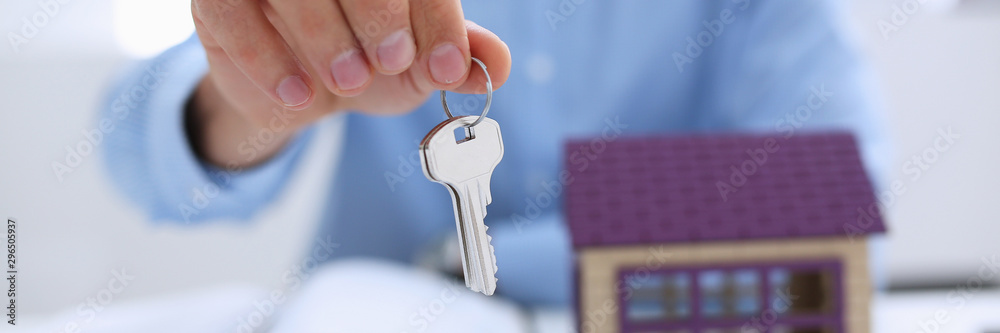 Male hand holds the key to the lock in the hand against the back Male hand holds the key to the lock in the hand against the back