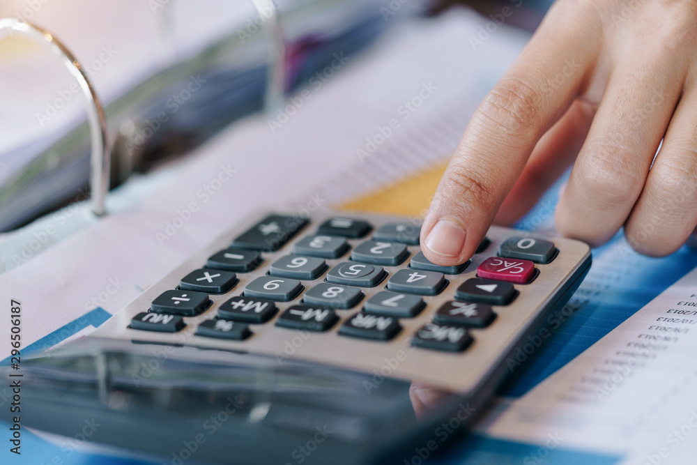 Close up of businesswoman working on calculator to calculate business data the financial report.Business financial analysis and strategy concept. Close up of businesswoman working on calculator to calculate business data the financial report.Business financial analysis and strategy concept.