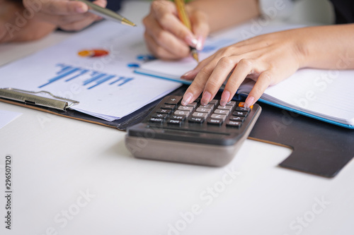 Businesswoman working on calculator to calculate business data the financial report in meeting room. Business financial analysis and strategy concept.
