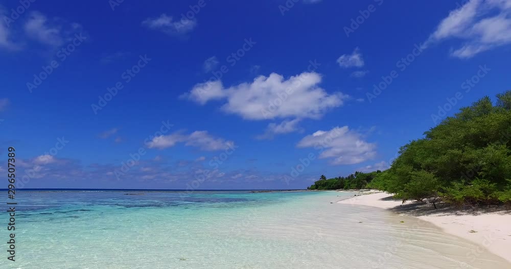 Looking out from a tropical beach scene with white sand and trees and panning to reveal crystal clear blue waters and fluffy clouds in the Mediterranean Looking out from a tropical beach scene with white sand and trees and panning to reveal crystal clear blue waters and fluffy clouds in the Mediterranean