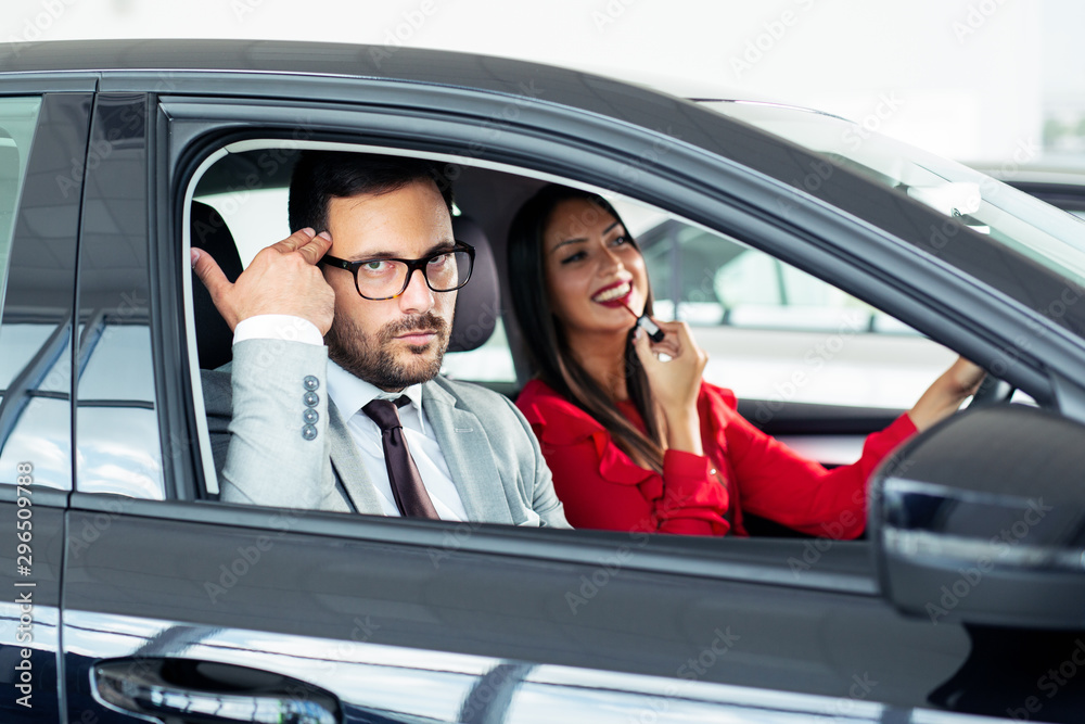 Young woman applying makeup in car