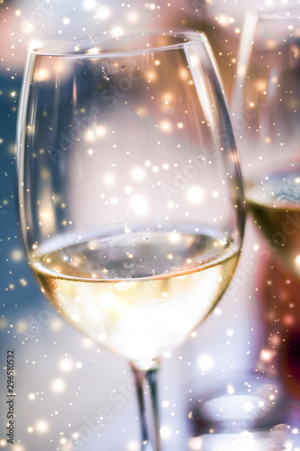 Canvas Print Winter holiday glasses of white wine and glowing snow on background, Christmas t