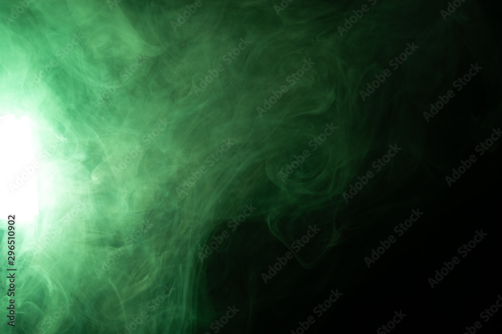 Green smoke on a black background in the spotlight Green smoke on a black background in the spotlight