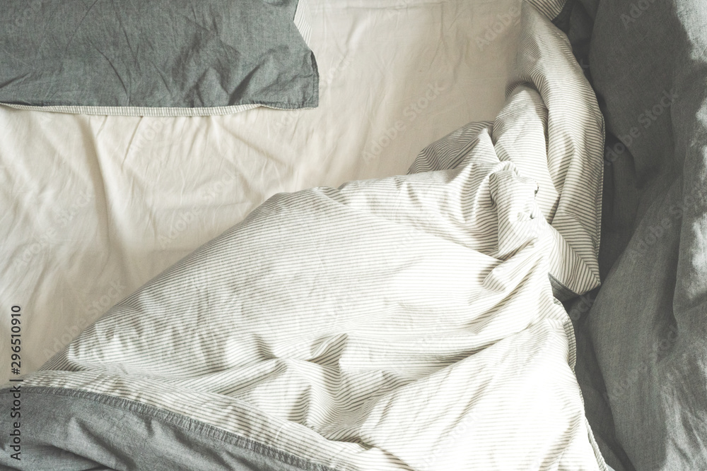 Crumpled gray fabric. Bed in the morning. The spread out bed. Linens.