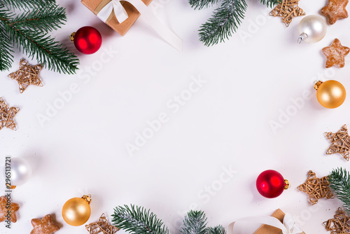 Christmas and New Year holiday composition. Mock up frame with fir branches, gift box, balls and stars on white background. Flat lay, top view festive concept.