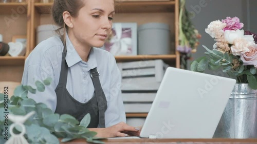 Female florist working on laptop at flower shop