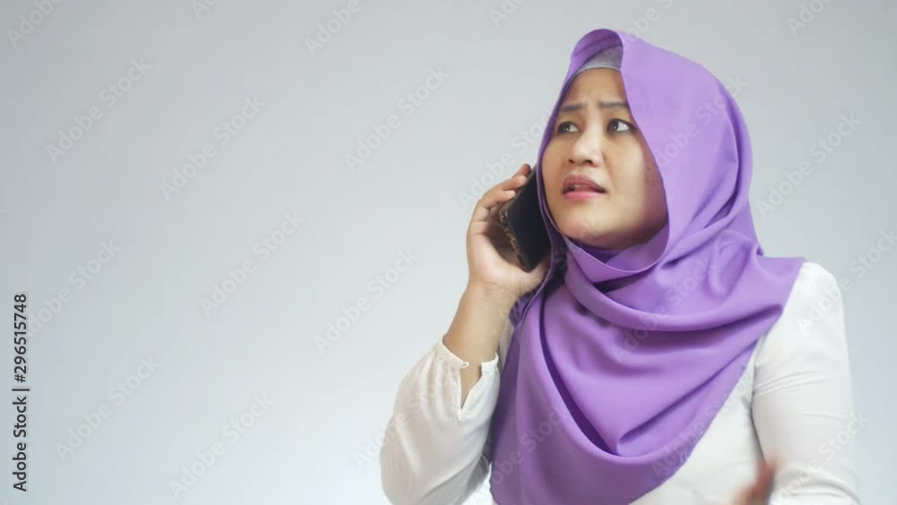 Portrait of muslim lady wearing hijab talking on phone, happy smiling laughing expression having good news Portrait of muslim lady wearing hijab talking on phone, happy smiling laughing expression having good news