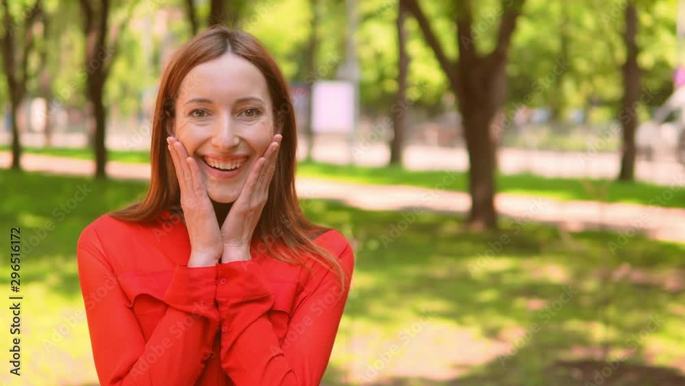 happy thrilled caucasian girl cheerful female in red shirt standing on the street nature summer background happy thrilled caucasian girl cheerful female in red shirt standing on the street nature summer background