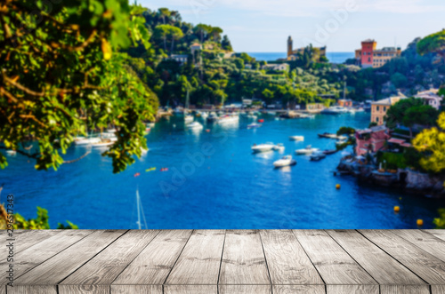 Wood table top on Blurred background of Manarola village on cliff rocks and sea at sunset.Seascape in Five lands, Cinque Terre ,Italy Europe.vintage tone color,can be used display your products © Angelov