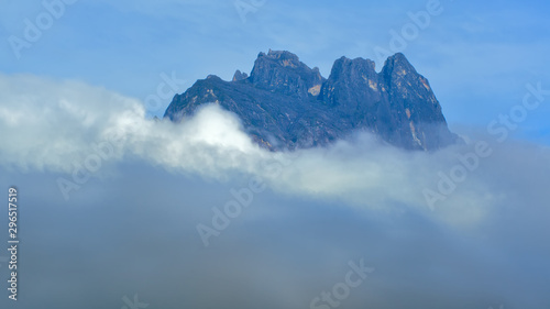 Mount Kinabalu peak surrounding with moving clouds.