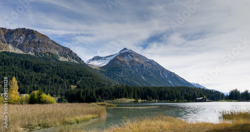 mountain lake landscape in autumn with snowy peaks behind