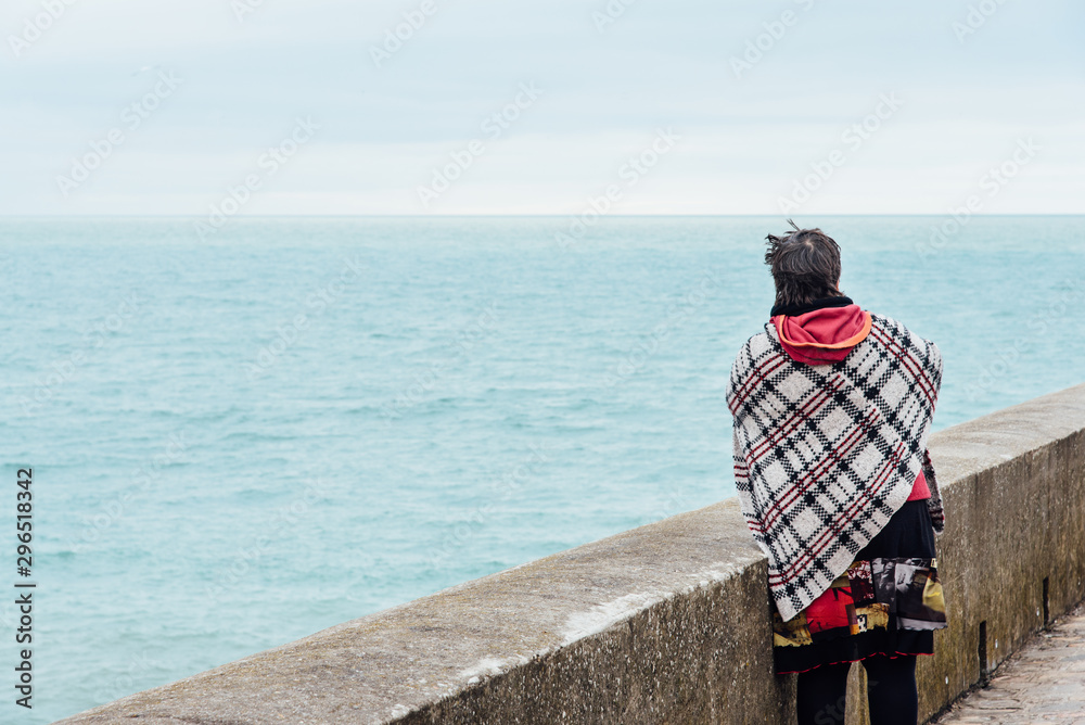 Une femme regarde la mer. Une touriste regarde la mer. Une femme en vacances regardant la mer. Une femme au bord de l'océan.