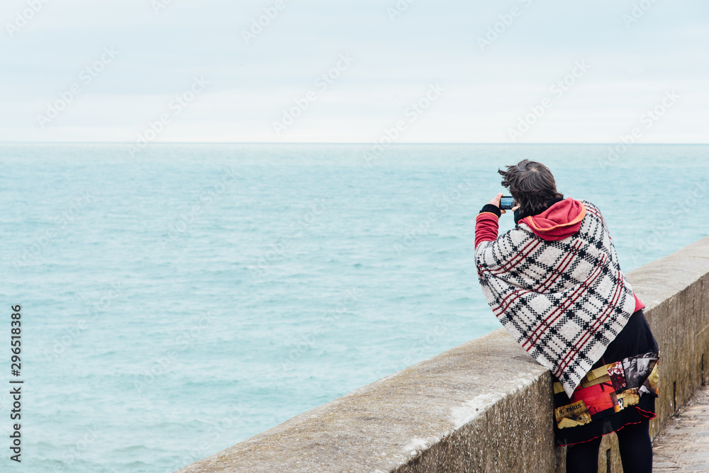 une femme photographie l'océan