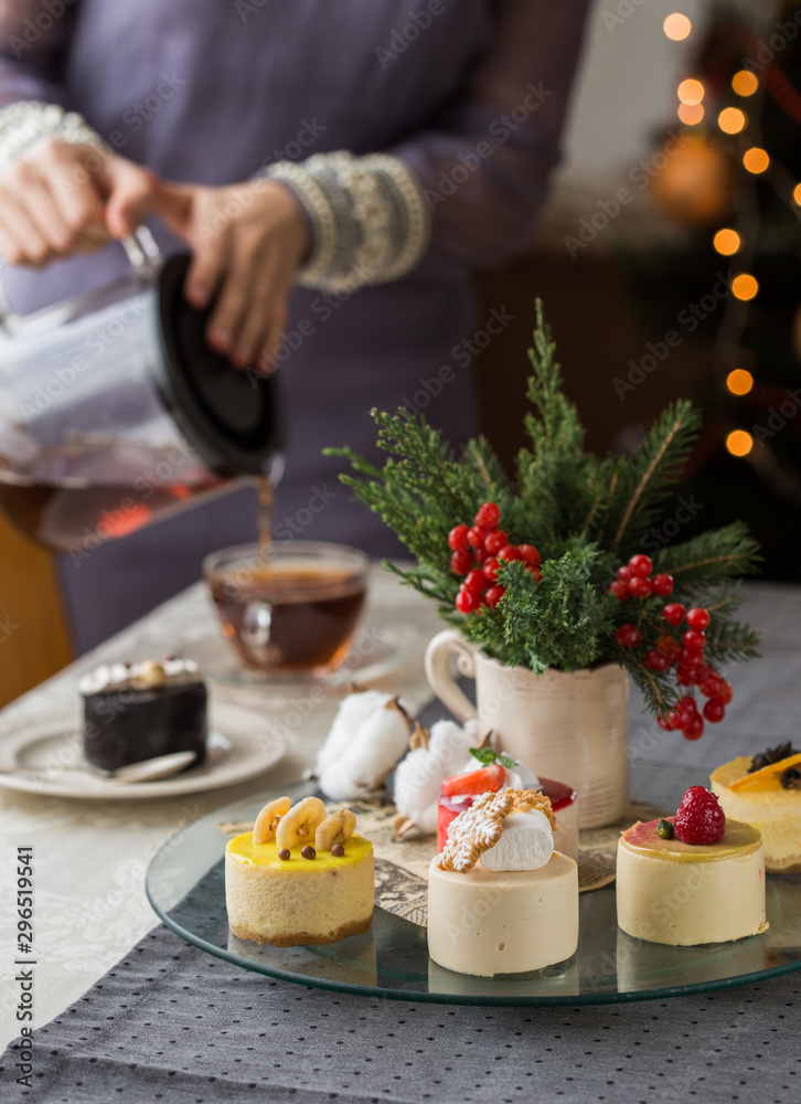 New Year and Christmas Glowing colorful lights on black background. festive cheesecake, with woman hand