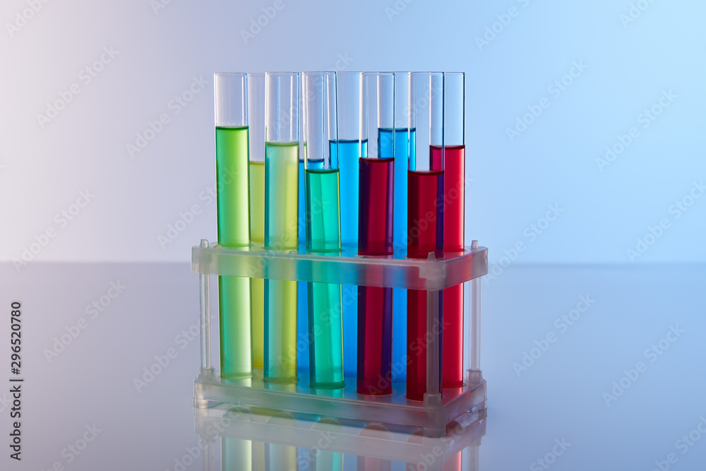 glass test tubes with colorful liquid on blue background glass test tubes with colorful liquid on blue background