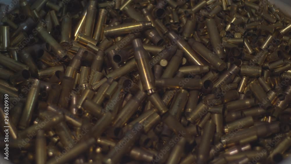 Empty bullet shells being dumped on pile of shell casings StockVideo