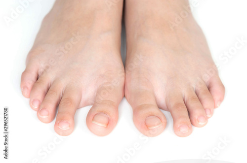 This is women's feet with long nails are not painted nails. Standing on a white background.