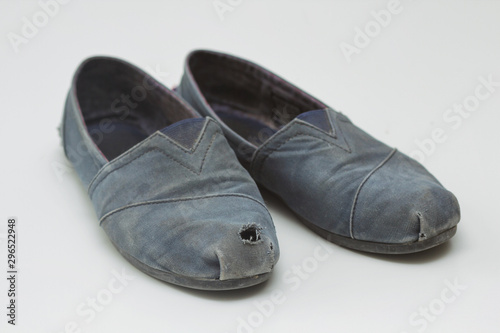 Old dirty rag boots with a hole. White background. Waste recycle. Problem of garbage. Reuse materials. Women's shoes.