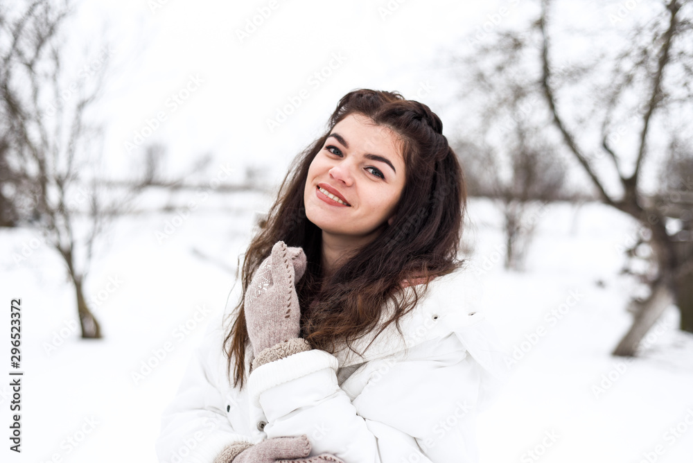 brunette in white jacket and warm gloves having fun brunette in white jacket and warm gloves having fun