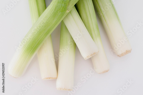 Bunch of fresh green and white leeks in a white background. Close up