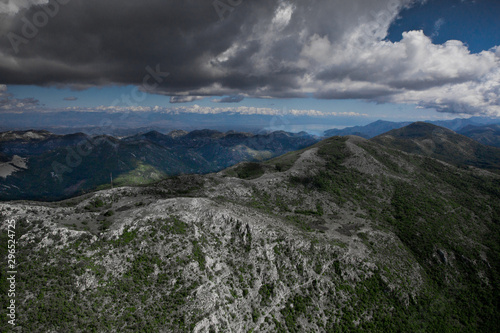 landscape below (aerial photo from a paraglider) with green mountains, severe with clouds. Montenegro