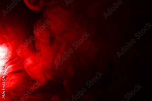 Puffs of red smoke on a black background - abstract background