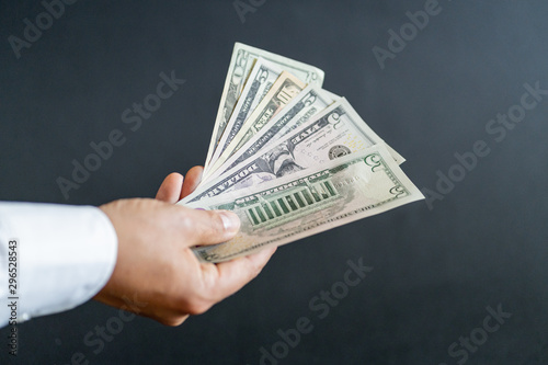 Bundle of banknotes in hand. Handing over dollars. American paper currency.