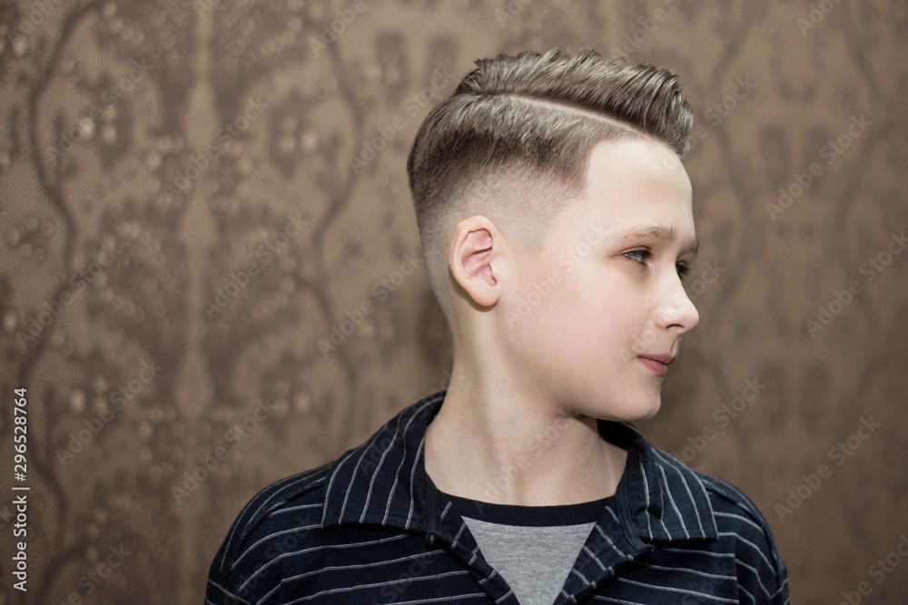 Stylish modern retro haircut side part with mid fade with parting of a  school boy guy in a barbershop on a brown background Stock Photo | Adobe  Stock