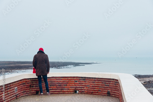 un homme face à la mer. Vue de dos d'un homme solitaire à la mer. Dépression. Réfléchir  seul. Un homme déprimé. Seul au monde. Observer l'horizon. photo