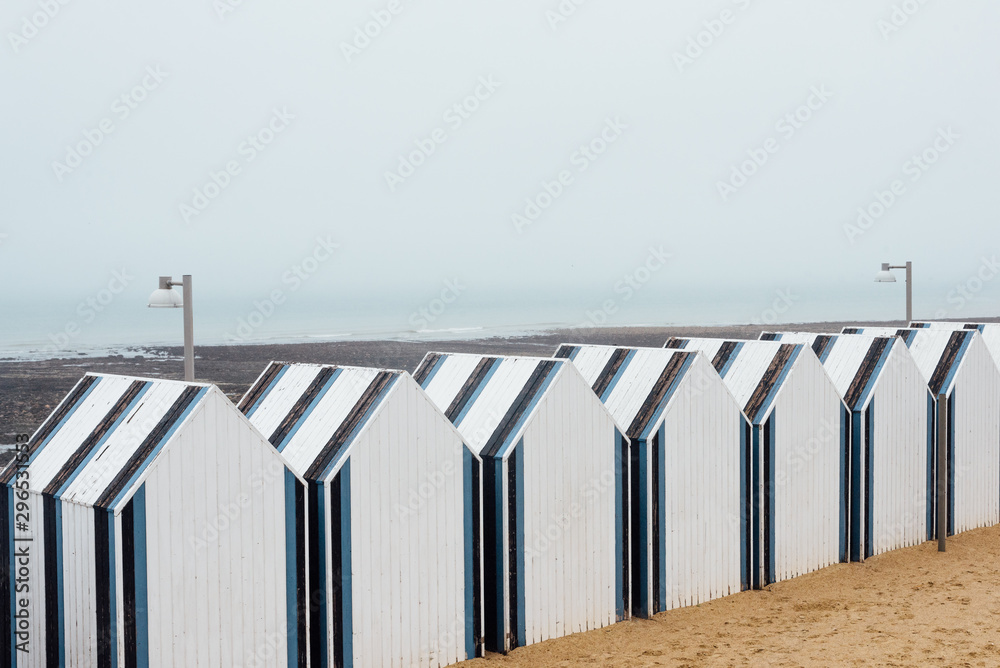 Naklejka premium Des cabines de plage en Normandie. Des cabines de plage bleues et blanches. Une plage du nord de la France