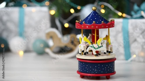 Christmas and New Year background. Wooden horse carousel in vintage style on shining garlands background. Festive mood. Christmas tree toys and gifts. Great for New Year and Christmas card