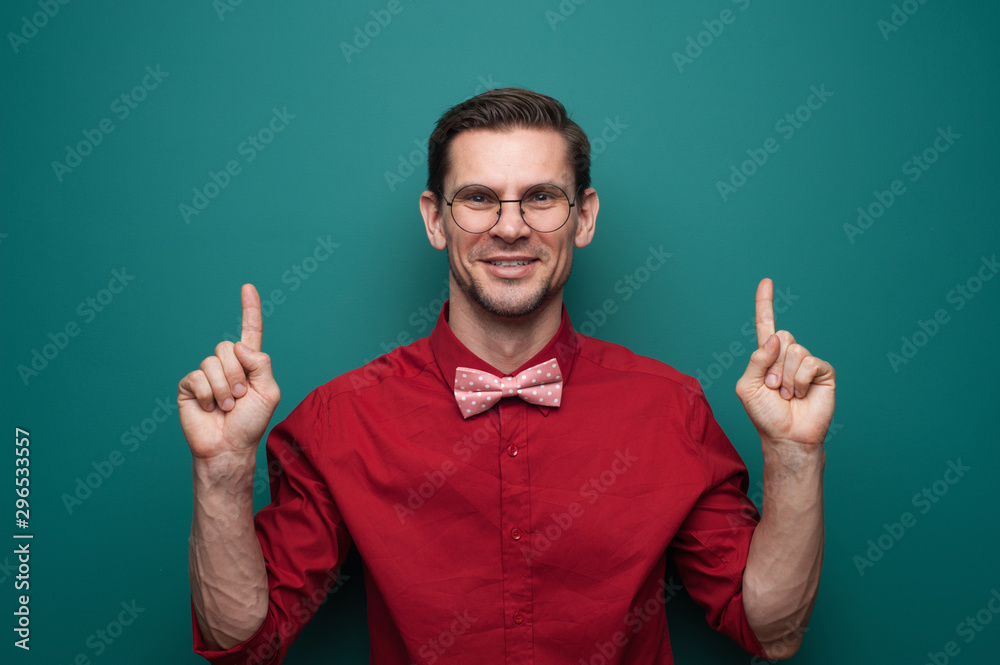 Portrait of a cute young man showing fingers on a green background Portrait of a cute young man showing fingers on a green background