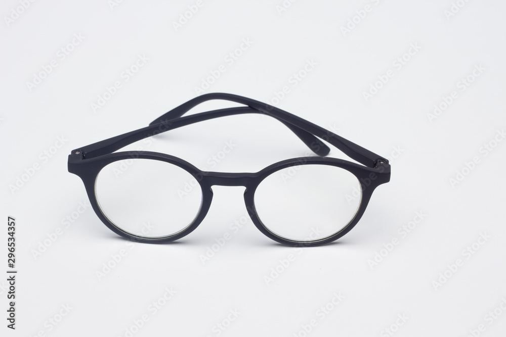 Gafas clásicas con cristales graduados, montura de plástico de color negro, sobre fondo negro Gafas clásicas con cristales graduados, montura de plástico de color negro, sobre fondo negro