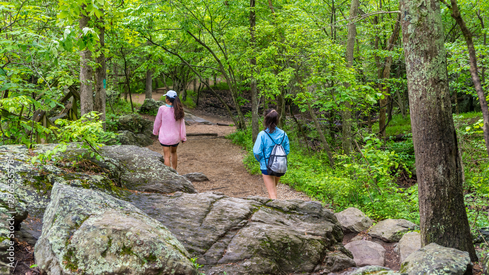 Obraz premium Mother and teen daughter walking down path