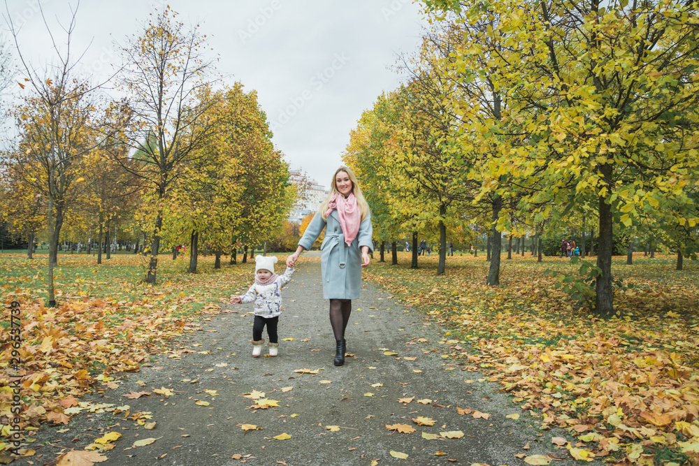 Fototapeta premium Young mother and her little daughter at beautiful autumn park
