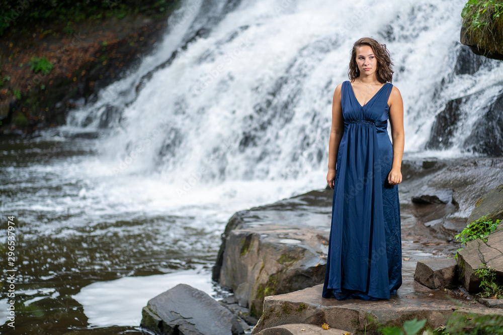 Teen Girl in a blue dress by a waterfall