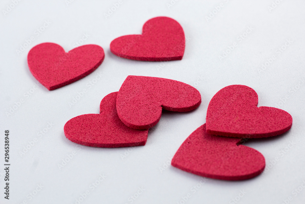 Obraz premium Red crafting foam hearts in white background. Decor hearts by cutting from red crafting foam