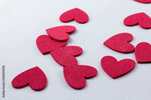Red crafting foam hearts in white background. Decor hearts by cutting from red crafting foam