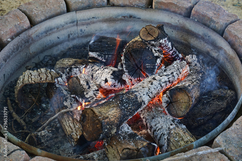 Wood campfire in a metal ring.