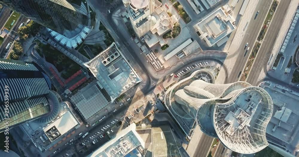 Down-looking aerial view of a global futuristic city, with skyscrapers, high rise towers and big avenues, circulation and cars, in Doha, the capital city of Qatar