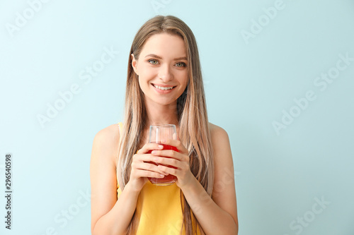 Woman with healthy juice on light background. Diet concept