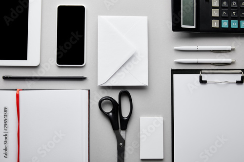 top view of clipboard, notebook, pens, pencil, calculator, business card, smartphone and digital tablet