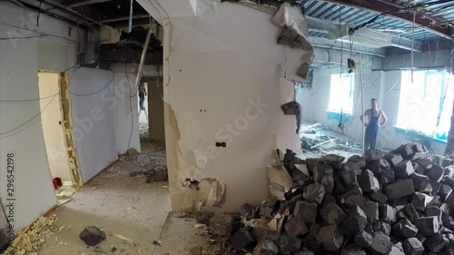 Timelapse of the wall in apartment being destroyed by two men. Demolition work in a flat photo