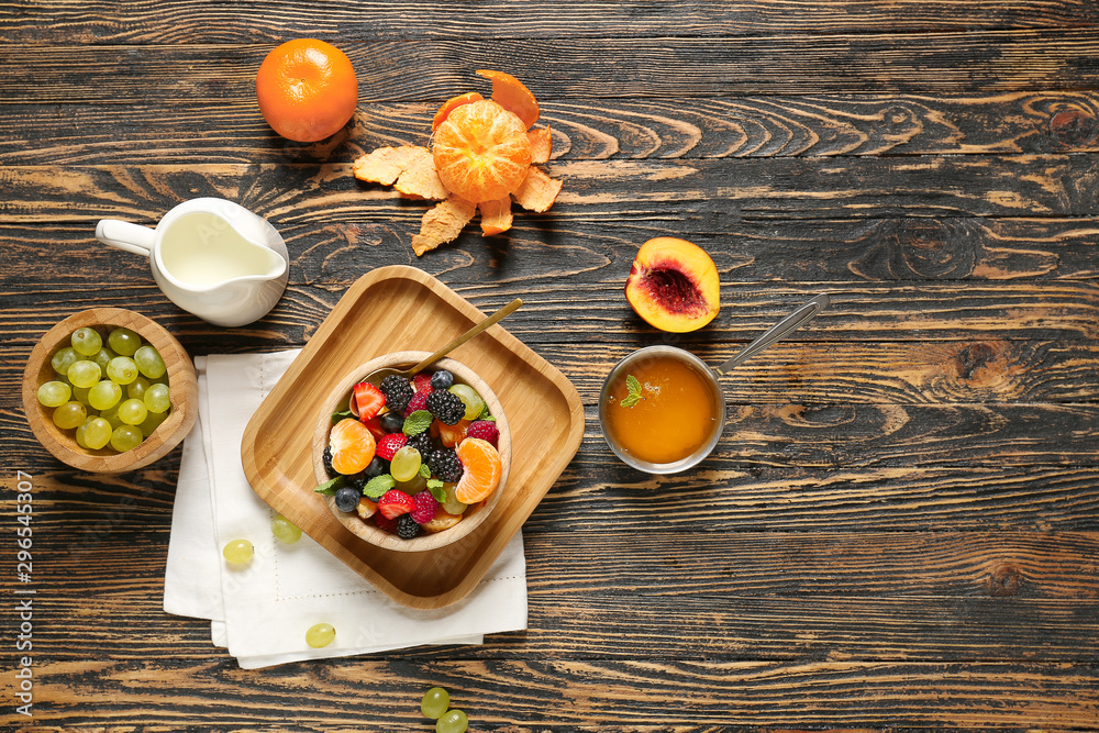 Bowl with tasty fruit salad on wooden table Bowl with tasty fruit salad on wooden table