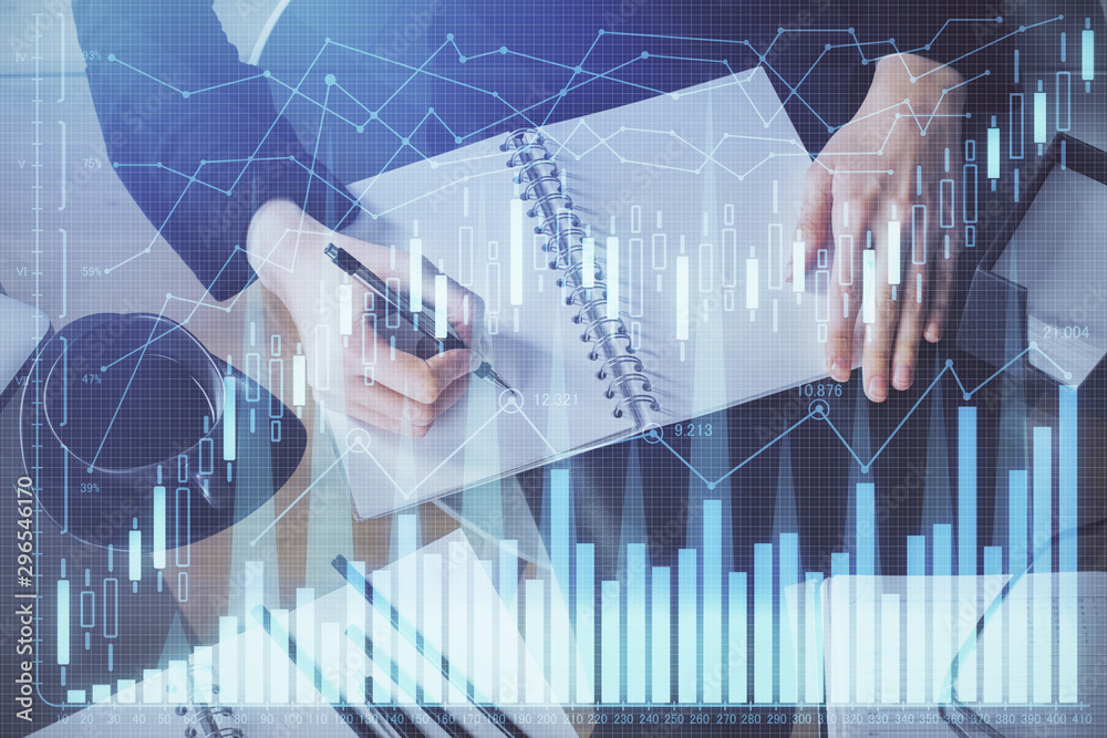 Forex chart hologram on hand taking notes background. Concept of analysis. Multi exposure Forex chart hologram on hand taking notes background. Concept of analysis. Multi exposure