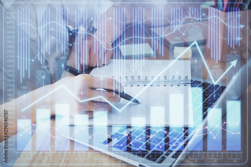 Financial charts displayed on woman's hand taking notes background. Concept of research. Double exposure © peshkova