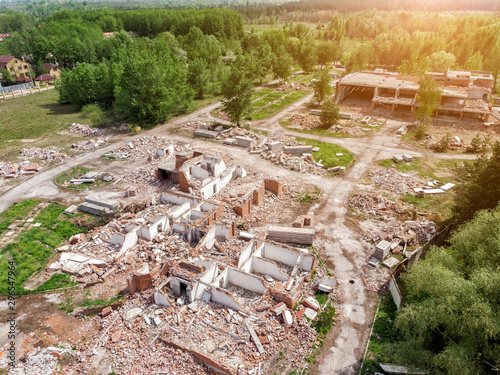 Aerial drone view of old demolished industrial building. Pile of concrete and brick rubbish, debris, rubble and waste of destruction ruins of abandoned actory or plant. Earthquake city landscape photo
