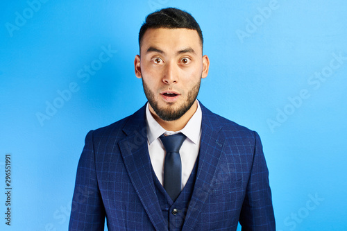 Photography Portrait of excited Kazakh Asian man with surprised open mouth and bulging eyes