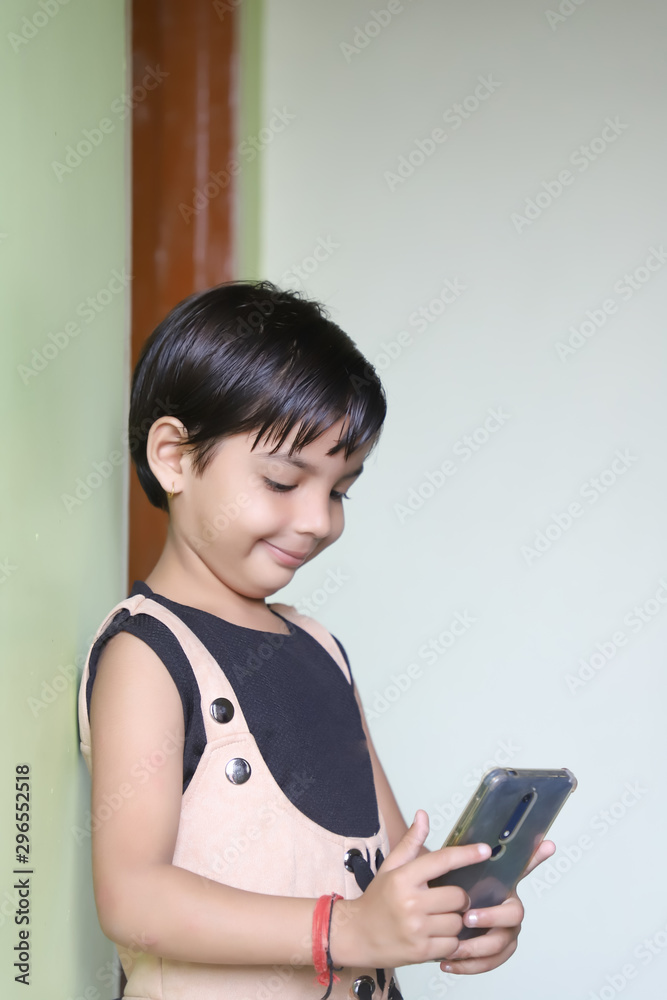 Indian child girl using smartphone Indian child girl using smartphone
